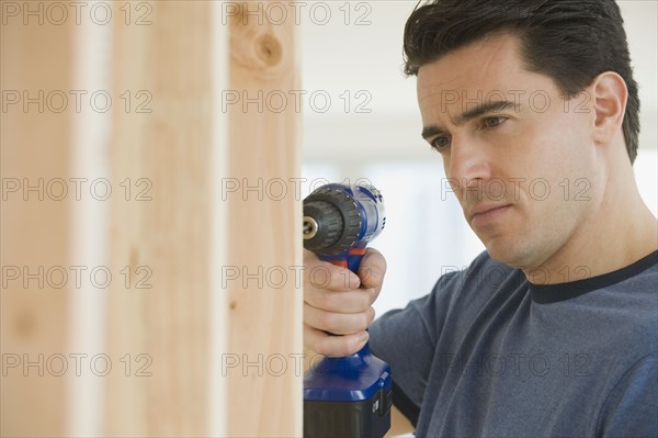 Man using cordless drill.