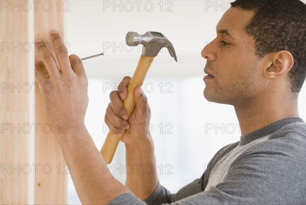 African man hammering nail.