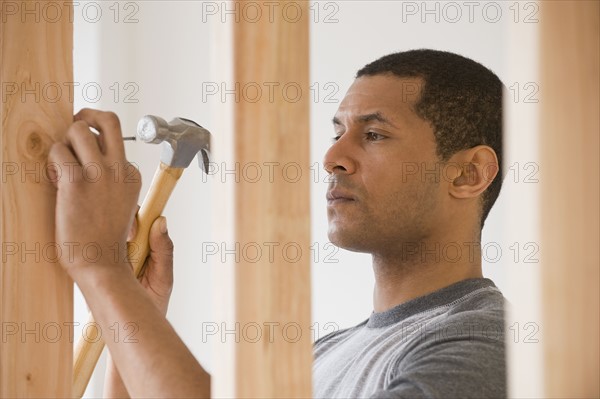 African man hammering nail.