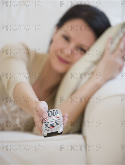 Woman pointing remote control.