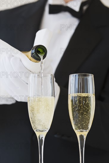 Waiter pouring champagne.