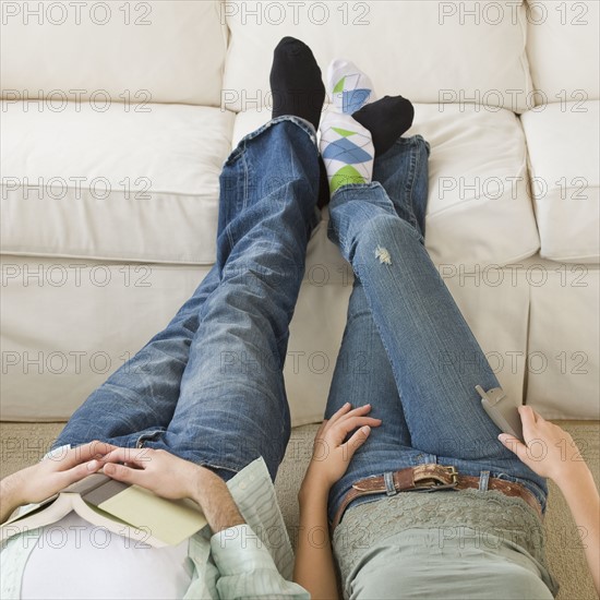 Couple with feet up on sofa.