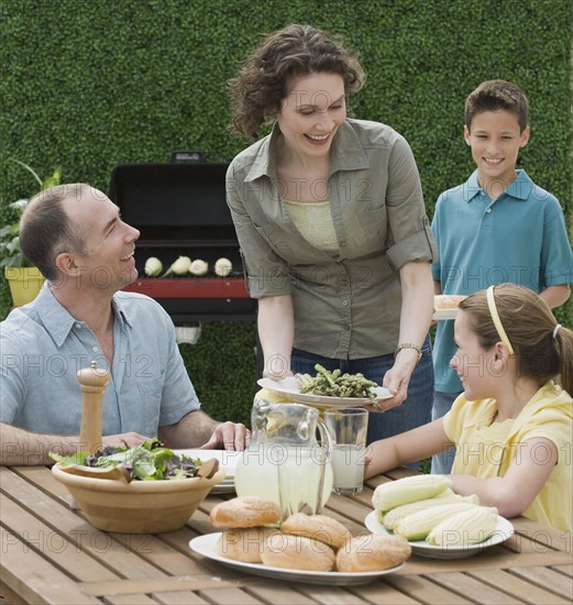 Family with two children barbecuing.