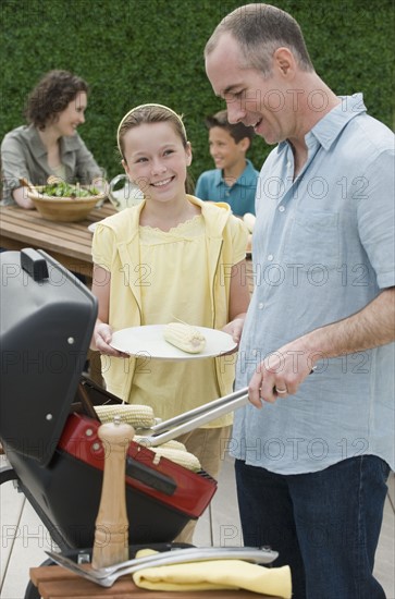 Family with two children barbecuing.