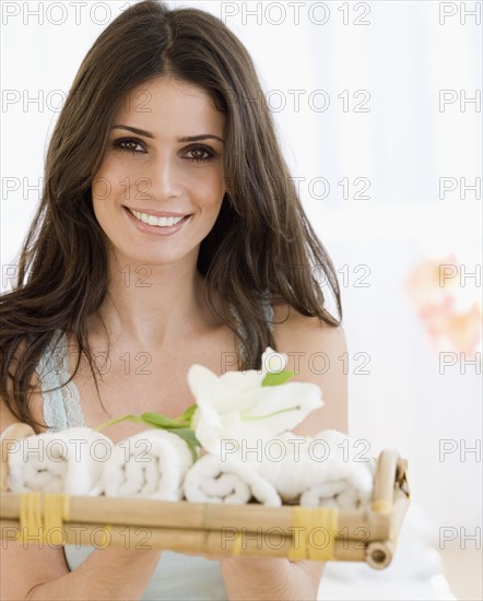 Woman holding tray of rolled towels. Date : 2008