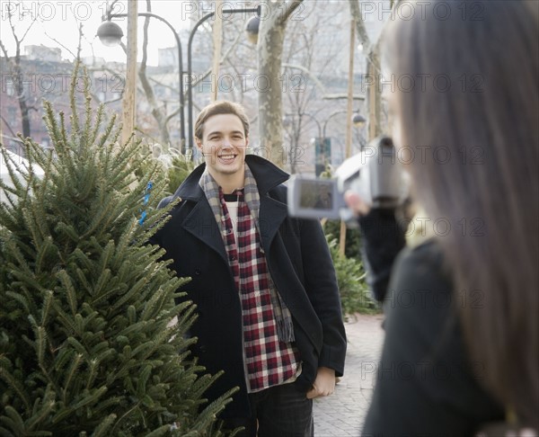 Woman video recording boyfriend with Christmas tree. Date : 2008