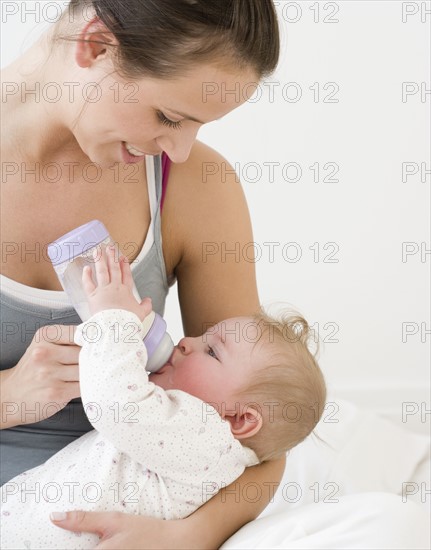 Mother feeding baby with bottle. Date : 2008