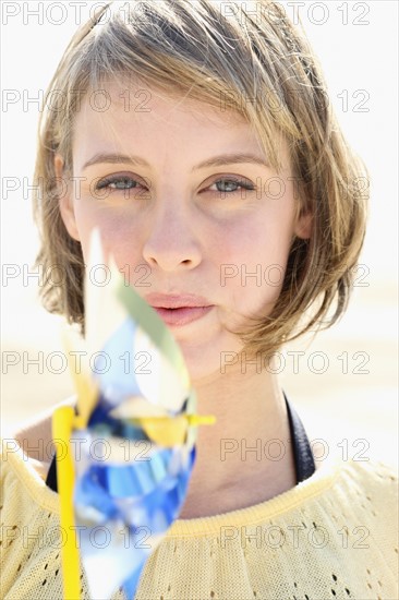 Woman blowing on pinwheel. Date : 2008