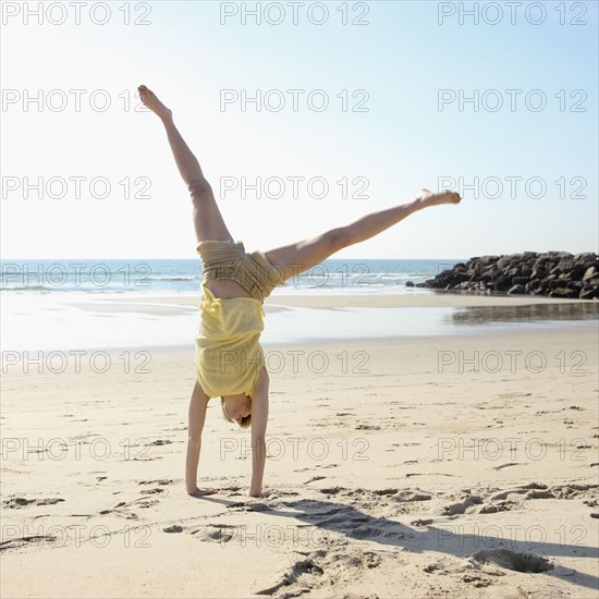Woman doing cartwheel on beach. Date : 2008