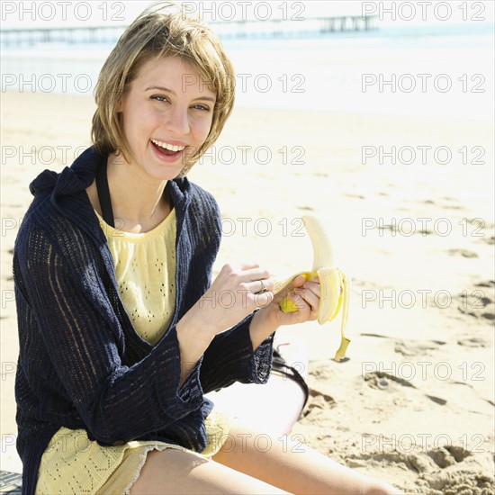 Woman peeling banana at beach. Date : 2008