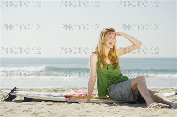 Woman sitting on surfboard. Date : 2008