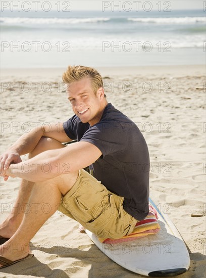 Man sitting on surfboard. Date : 2008