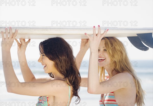 Two women holding surfboard on heads. Date : 2008