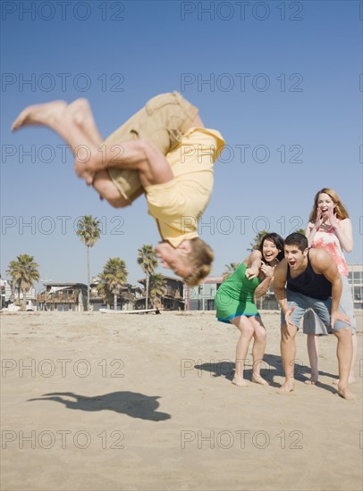 Man doing back flip on beach. Date : 2008