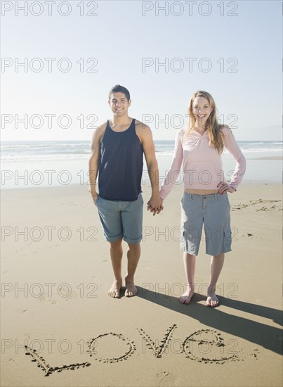 Couple next to Love written in sand. Date : 2008