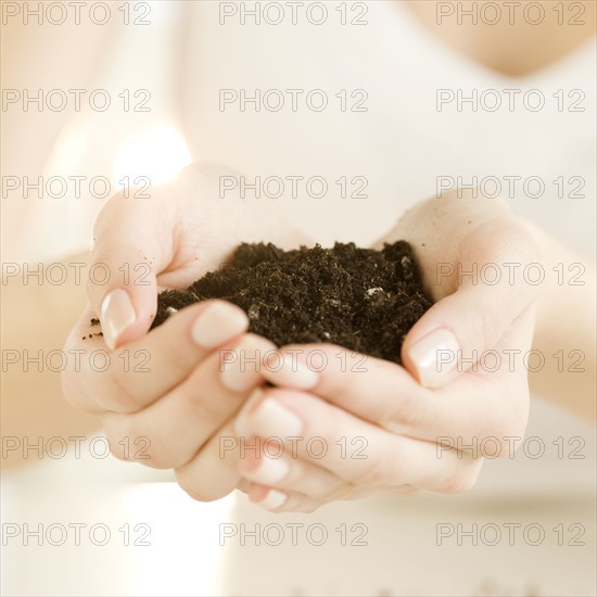 Woman holding handful of soil. Date : 2008