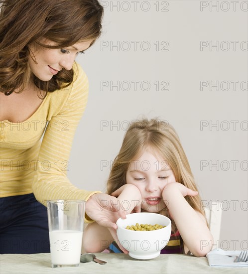 Mother serving vegetables to daughter. Date : 2008