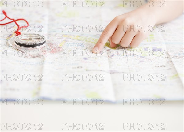 Child pointing at map next to compass. Date : 2008