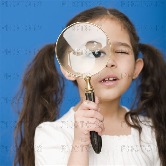 Hispanic girl looking through magnifying glass. Date : 2008