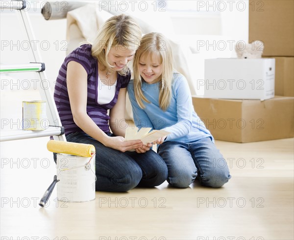 Mother and daughter looking at paint swatches. Date : 2008