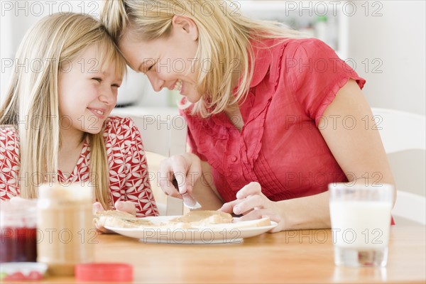 Mother and daughter making sandwich. Date : 2008