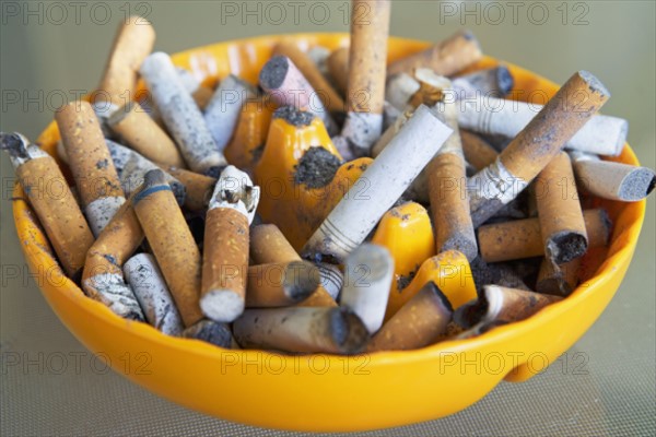 ashtray filled with many cigarette butts. Date : 2008