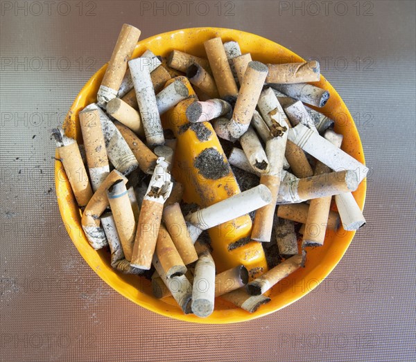 ashtray filled with many cigarette butts. Date : 2008