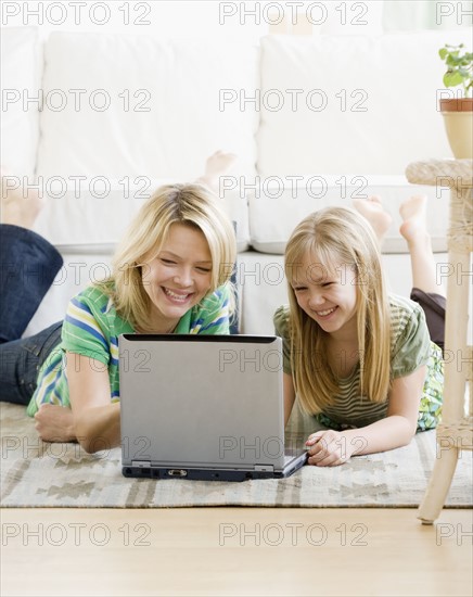 Mother and daughter looking at laptop. Date : 2008