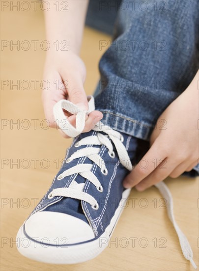 Close up of child tying shoe. Date : 2008