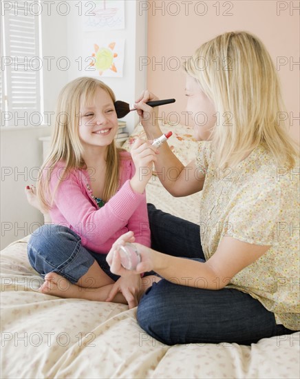 Mother and daughter applying makeup. Date : 2008