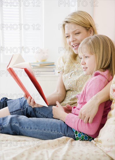 Mother reading to daughter. Date : 2008