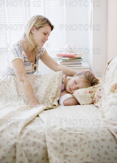 Mother watching daughter sleep. Date : 2008