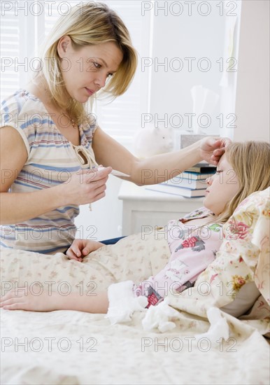 Mother checking daughter’s temperature. Date : 2008