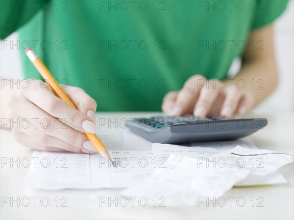 Woman adding receipts. Date : 2008