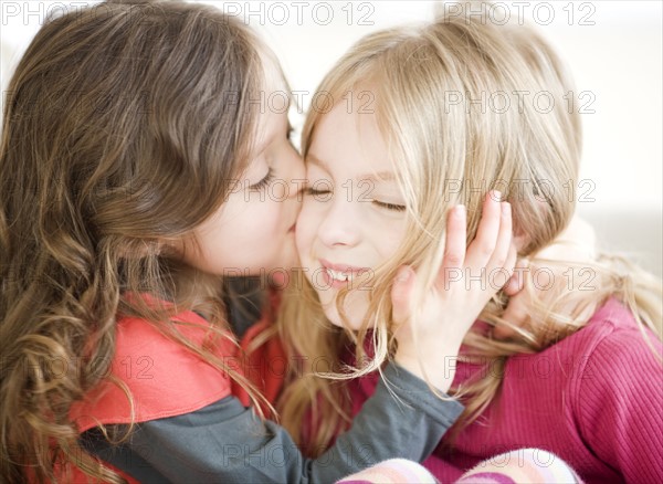 Girl kissing sister on cheek. Date : 2008