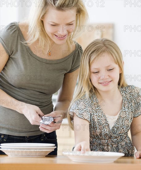 Mother and daughter setting table. Date : 2008