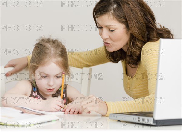 Mother helping daughter with homework. Date : 2008