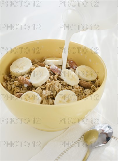 Milk pouring into cereal bowl. Date : 2008