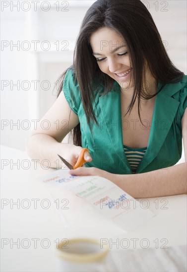 Woman cutting out coupon. Date : 2008