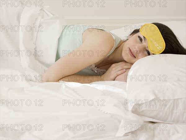 Woman laying in bed with eye mask. Date : 2008