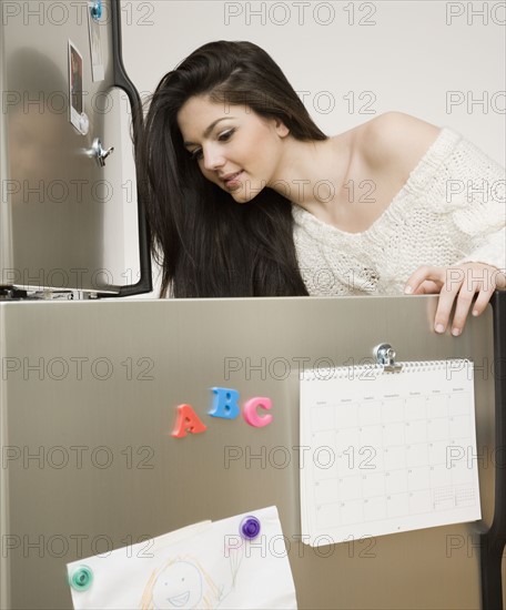 Woman looking in refrigerator. Date : 2008