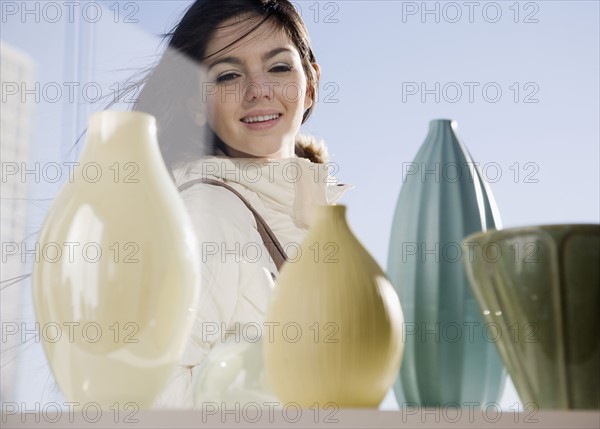 Woman looking at pottery in window. Date : 2008