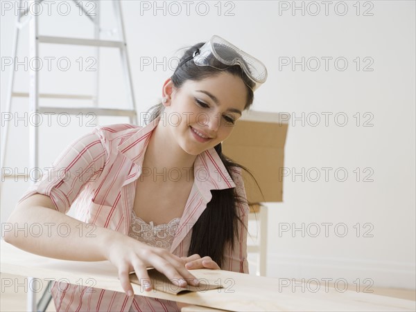 Woman sanding piece of wood. Date : 2008