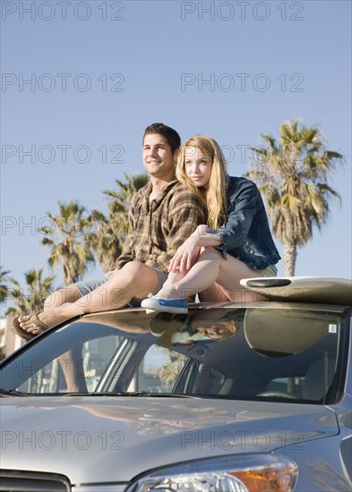 Couple sitting on top of car. Date : 2008