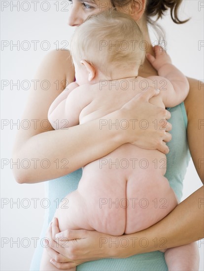 Mother hugging naked baby. Date : 2008