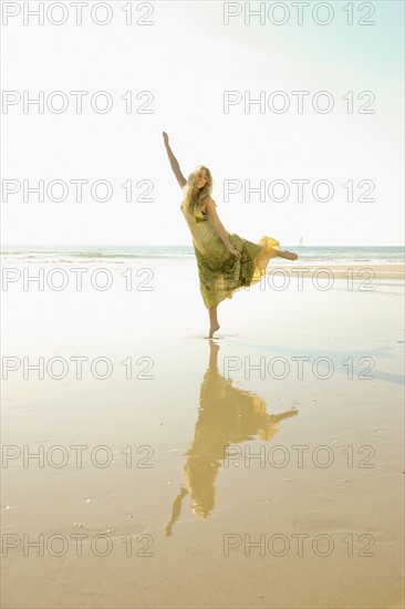 Woman standing on one foot at beach. Date : 2008