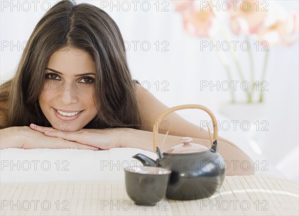 Woman laying next to tea pot and cup. Date : 2008