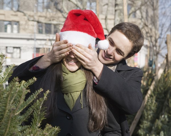 Man holding hands over girlfriend’s eyes. Date : 2008