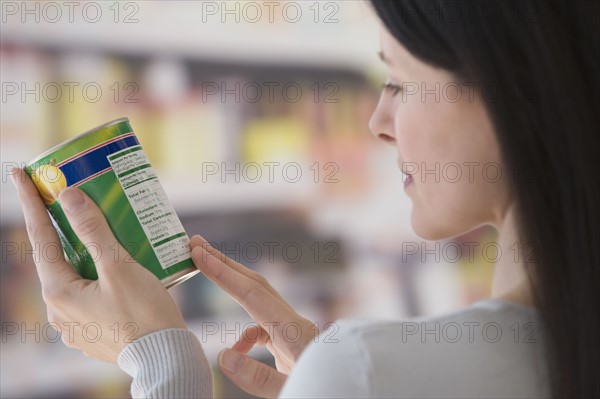 Woman reading label at grocery store.