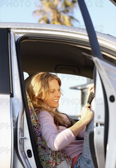 Woman sitting in car with door open. Date : 2008